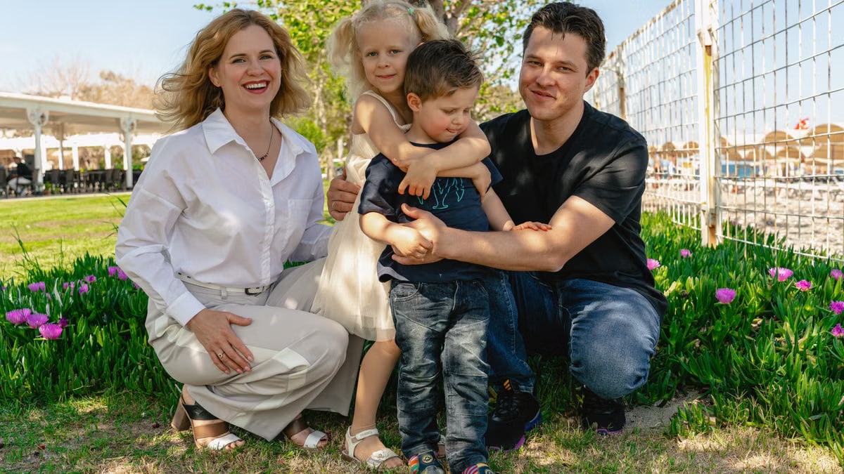 Family of four enjoying a sunny day outdoors in Kemer, smiling and spending quality time together.